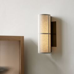 a wall mounted lamp next to a wooden frame with a light fixture on it's side