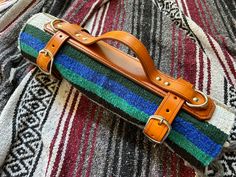 a colorful striped blanket with leather straps on it