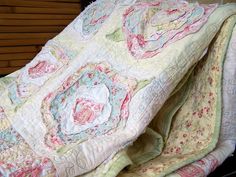 an old quilt is laying on top of a bed with the sheets pulled back and folded down