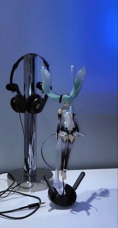 a couple of figurines sitting on top of a table next to headphones