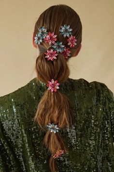 a woman with long hair and flowers in her hair is wearing green sequins