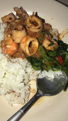 a white plate topped with rice and shrimp