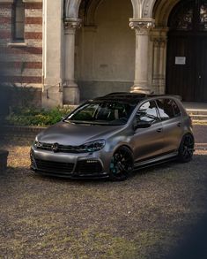 a grey car parked in front of a building