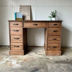 a wooden desk with drawers and a potted plant on top