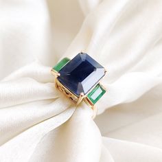 This stunning ring is set in 14k Solid Yellow Gold with Natural Blue Sapphire and Emerald  with utmost precision. It is an unique statement gemstone ring for nearly every occasion and is completely hassle-free jewelry. ITEM DETAILS * Center Gem: Blue Sapphire * Gem Size: 10X12mm * Gem Shape: Octagon * Side Gem: Emerald * Gem Size: 3X6mm * Gem Shape: Baugette * Gem Weight: 8.80 carats * Gold Purity: 14KT * Gold Weight: 2.26 gram * Total Weight of the Ring: 4.02 gram The Gold purity is guaranteed and it comes with authentic 14KT gold hallmark. Since my items are handmade, they are absolutely nickel and lead free. CUSTOMIZATION * The same design is available in various gemstone combinations on my Etsy Shop. You can choose your own gemstone as well. Kindly drop me a message for the same. PACKA Sapphire Emerald Ring, Sapphire Gem, Gold Skies, May Birthstone Rings, Handmade Jewelry Box, Smoky Quartz Ring, Emerald Gem, May Birthstone, Sky Blue Topaz