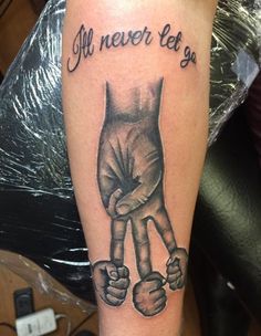 a black and white tattoo with an image of two hands holding each other