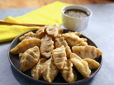 a plate full of dumplings with dipping sauce