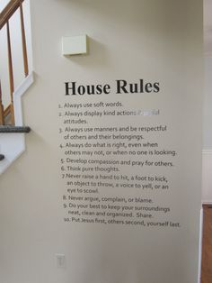 there is a sign on the wall that says house rules and below it are stairs