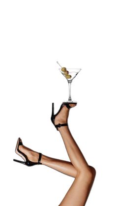 a woman in high heels holding a martini glass