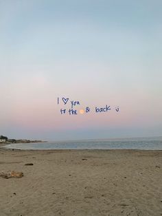 i love you to the moon and back written in blue ink on a sandy beach