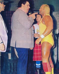 two men in yellow wrestling suits talking to each other
