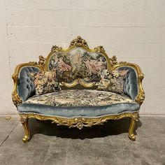 an ornately decorated couch sitting in front of a white wall