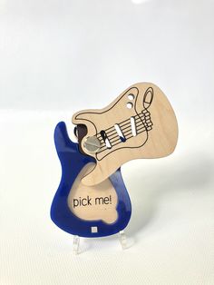 a wooden toy guitar with the words pick me on it's body and neck