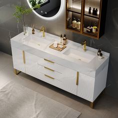 a bathroom vanity with two sinks and a round mirror above it, in front of a gray wall