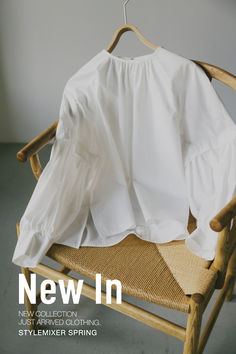 a white shirt on a wooden chair with the words new in next to it's image