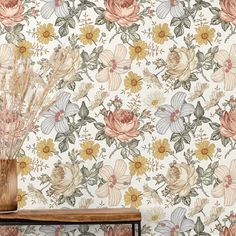 a vase filled with dried flowers on top of a wooden table next to a wall