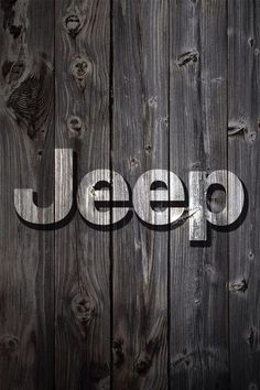 the word jeep written in white on a wooden wall with dark wood grained planks