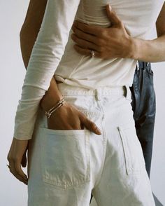 two people standing next to each other with their hands on their hipss and one holding the other's stomach