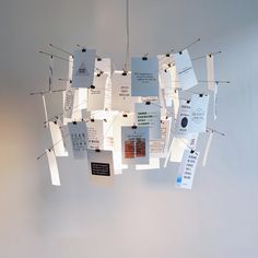 several pieces of paper hanging from the ceiling with pins stuck to them and pinned together