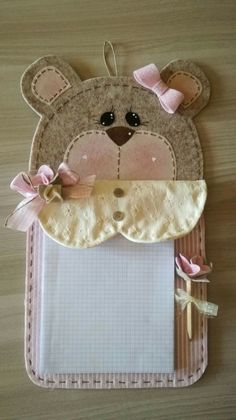 a teddy bear with a pink bow on it's head is attached to a clipboard