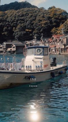 a small boat floating on top of a body of water next to houses and trees