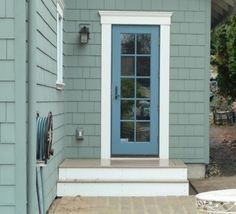 a blue front door on a gray house