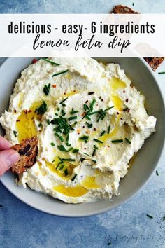 a bowl filled with mashed potatoes and topped with lemon zestya dip on a blue surface