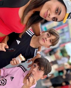 three young people standing next to each other with food in their hands and looking at the camera