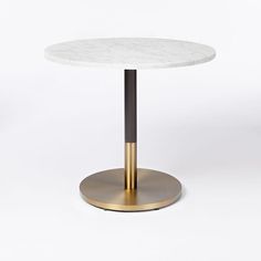 a white table with a gold base and a marble top that has a black metal ring around it