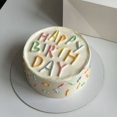 a birthday cake with white frosting and multicolored sprinkles on it