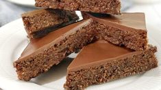 several pieces of chocolate and granola bars stacked on top of each other in a white plate