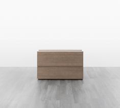 a wooden dresser sitting on top of a hard wood floor next to a white wall
