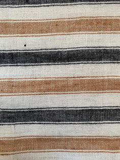 an orange, black and white striped fabric with some small dots on the bottom of it