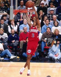 a basketball player dunking the ball in front of an audience