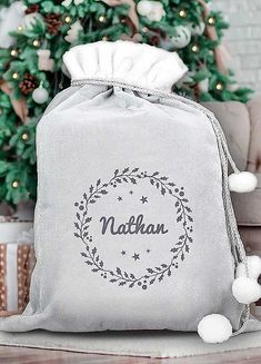 a bag with the name nathan on it sitting in front of a christmas tree and presents