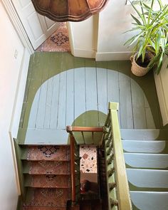 an overhead view of a staircase with green painted walls and wooden steps leading up to the second floor