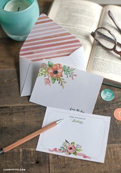 an open book and some cards on a table next to a pair of eyeglasses