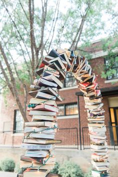 a tall stack of books sitting on top of a sidewalk