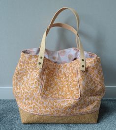 an orange and white purse sitting on top of a blue carpeted floor next to a wall