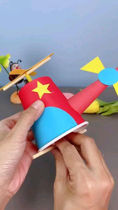 someone is making a toy airplane out of construction paper