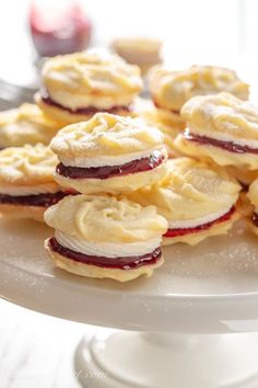 a white plate topped with cookies covered in butter and jelly filling on top of a table