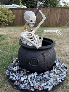 a skeleton in a cauldster with a knife and fork sitting on top of it