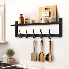 kitchen utensils are hanging on the wall above the stove