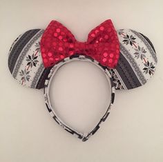 a minnie mouse ears headband with red sequins and a bow on it