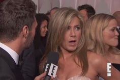 an image of a woman talking to someone on the red carpet in front of other people