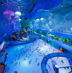 an indoor water park with people playing and swimming