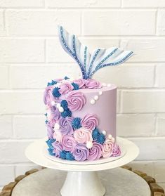 a pink and blue cake sitting on top of a table