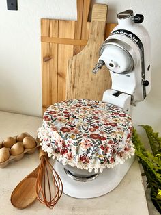 a cake sitting on top of a white counter next to a whisk and wooden spoon