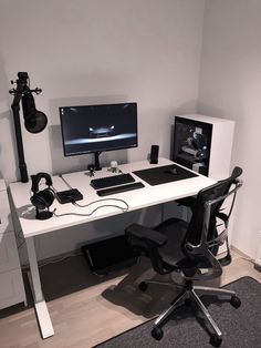 a computer desk with two monitors and headphones sitting on it's legs in front of a white wall