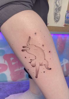 a woman's leg with a small tattoo of a dog on the left thigh